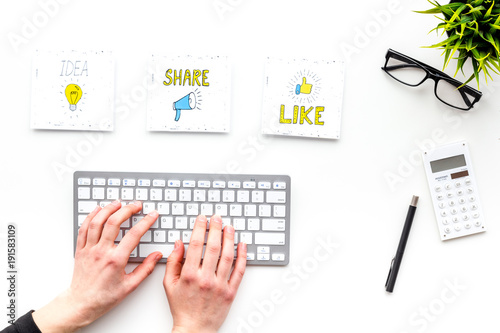 Blogger desk with social media icons and computer. Hands type on keyboard on white background top view