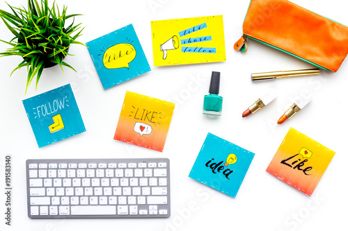 Work desk of beauty blogger with social media icons and cosmetics on white background top view