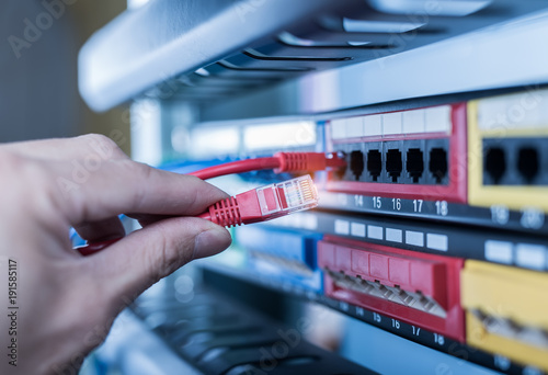 administrator holding network cables connected to servers