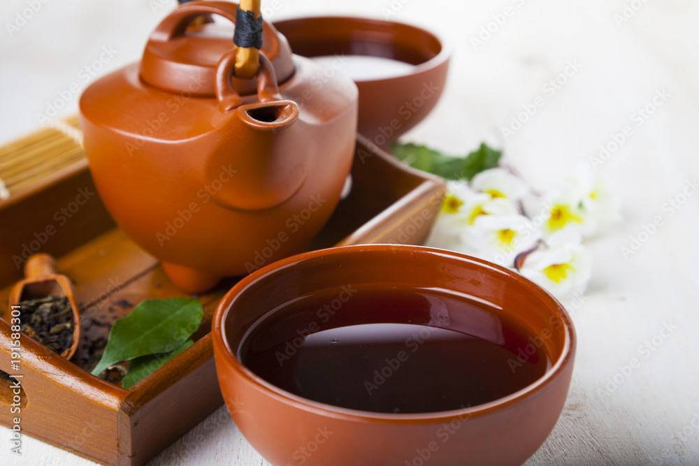 Ceramic teapot, tea leaves and sakura Ceramic teapot, tea leaves and sakura