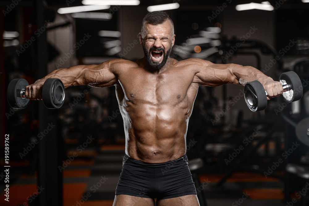 Old brutal strong bodybuilder athletic men pumping up muscles with dumbbells