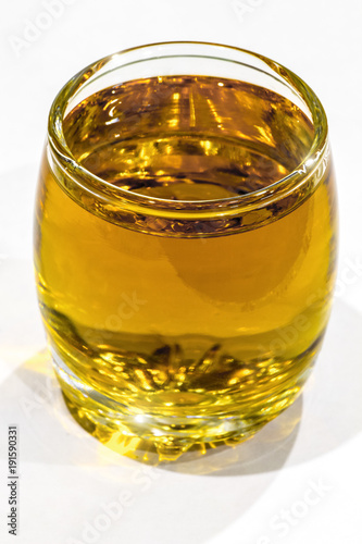A glass of strong alcoholic beverage on a white background close-up.