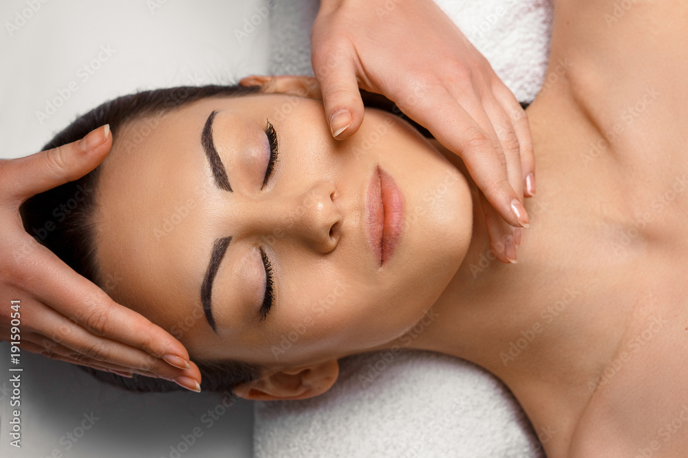 Naklejka premium Masseur Doing Massage The Head Of Woman In The Spa Salon