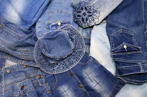 Blue denim background. Variety of jean clothes close up.