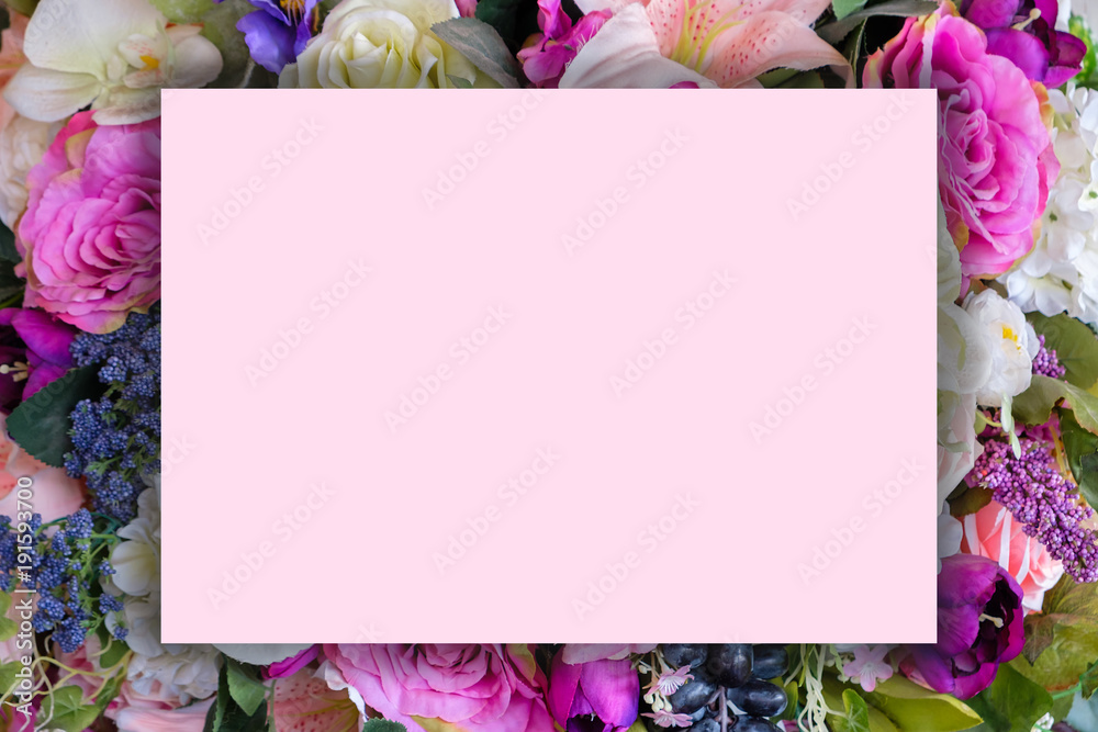 Fototapeta Pink paper is placed on various flowers.