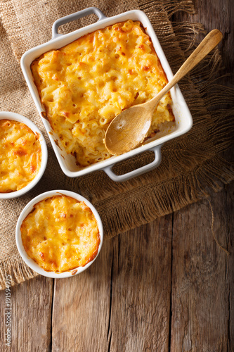 Delicious and hearty meal: casserole mac and cheese in a baking dish close-up. Vertical top view