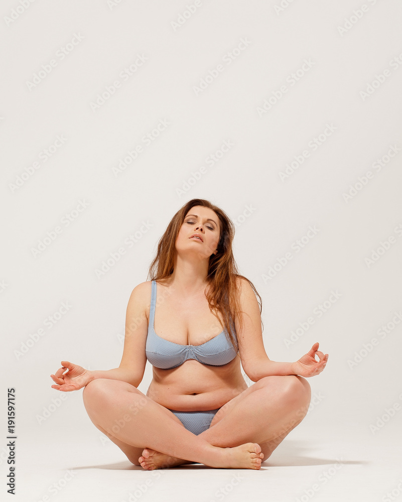 Beautiful girl in underwear sitting on floor and meditating. Beautiful girl in underwear sitting on floor and meditating.