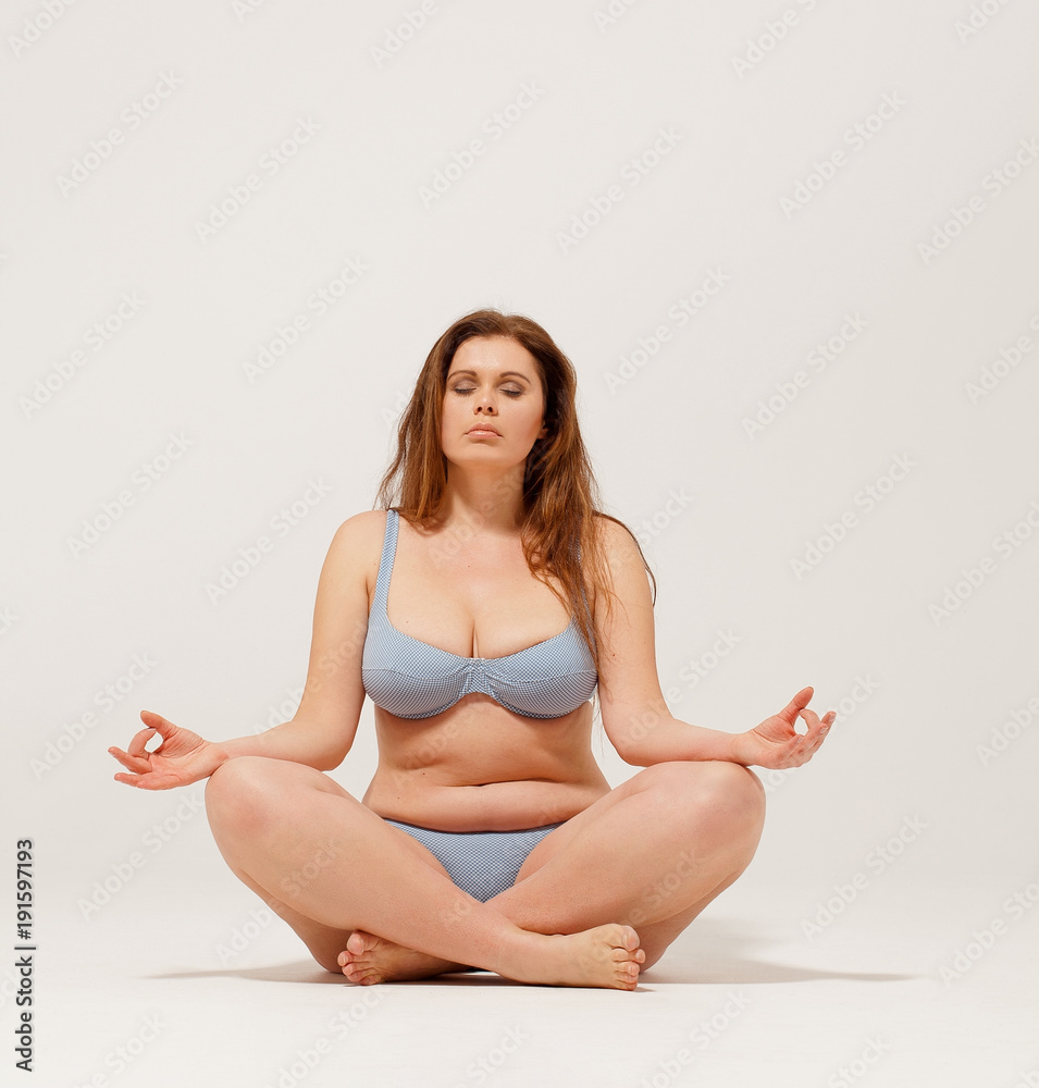 Nice but overweight girl meditating on floor in underwear. Nice but overweight girl meditating on floor in underwear.