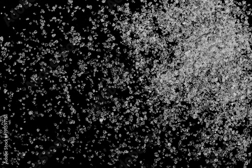 Salt grains, crystals isolated on black background, top view