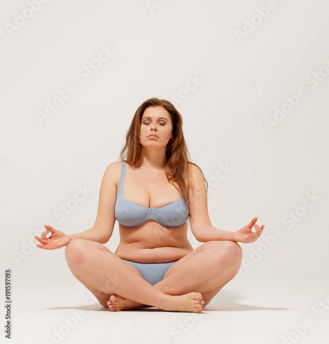 Cuadro en lienzo Nice but overweight girl meditating on floor in underwear.