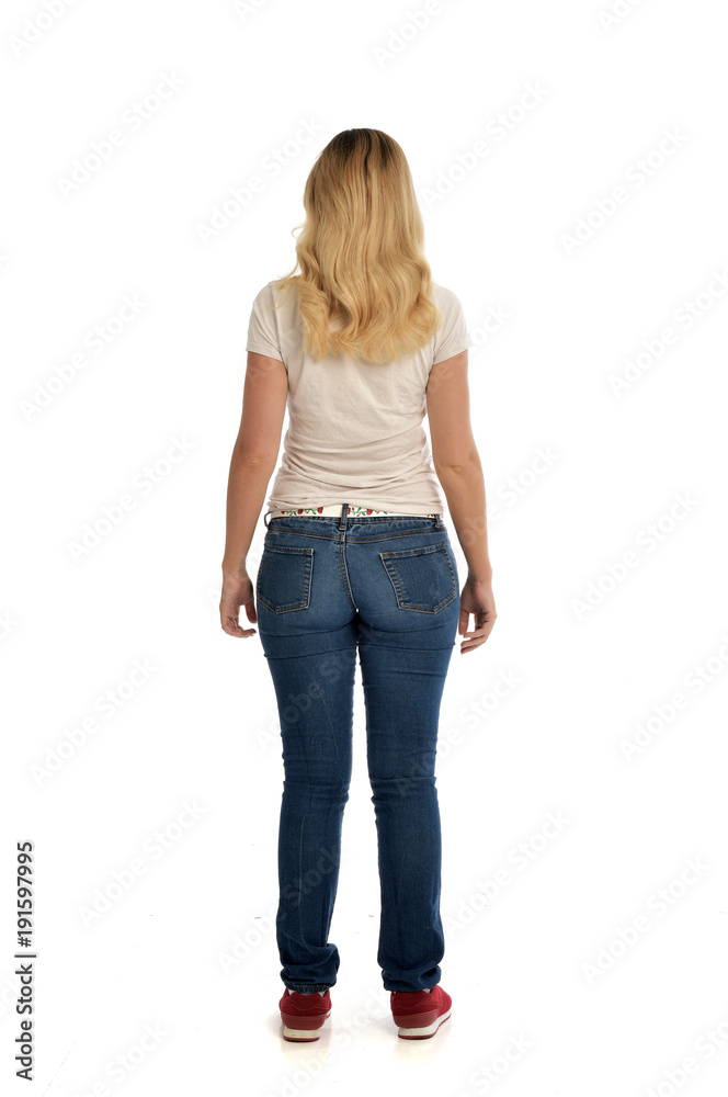 full length portrait of blonde lady wearing simple white shirt and jeans, standing pose isolated on white studio background. full length portrait of blonde lady wearing simple white shirt and jeans, standing pose isolated on white studio background.