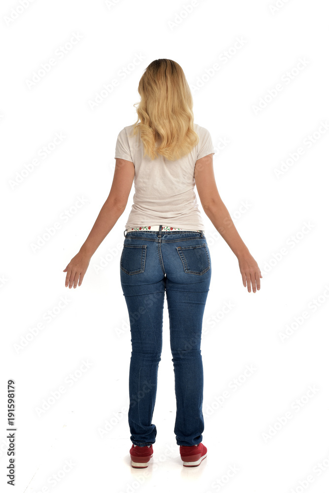 full length portrait of blonde lady wearing simple white shirt and jeans, standing pose isolated on white studio background. full length portrait of blonde lady wearing simple white shirt and jeans, standing pose isolated on white studio background.