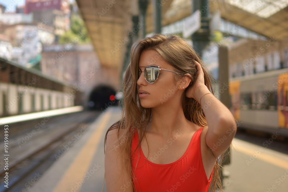 chica joven con gafas de sol en estación de tren
