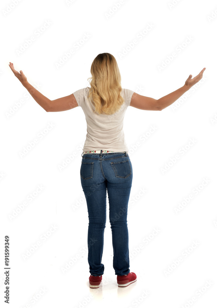 full length portrait of blonde lady wearing simple white shirt and jeans, standing pose isolated on white studio background. full length portrait of blonde lady wearing simple white shirt and jeans, standing pose isolated on white studio background.