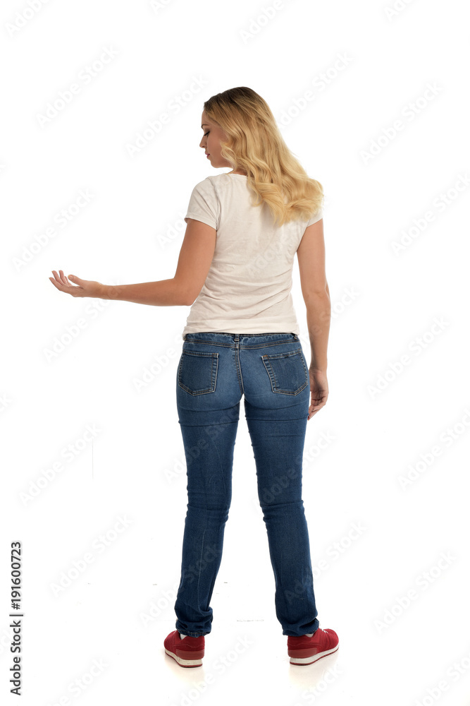 full length portrait of blonde lady wearing simple white shirt and jeans, standing pose isolated on white studio background. full length portrait of blonde lady wearing simple white shirt and jeans, standing pose isolated on white studio background.