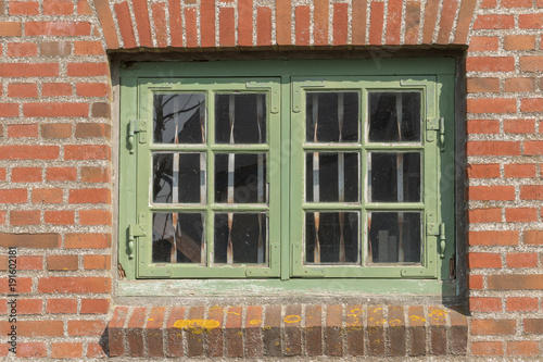 Grünes Fenster in einer Mauer eines Hauses