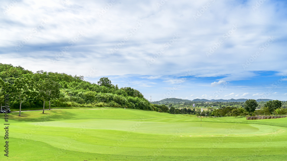 The green grass on golf course with blue cloud sky background The green grass on golf course with blue cloud sky background