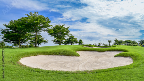 Quadro su tela The sand bungker in golf course with blue cloud sky background