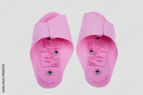 Pink spa slippers massage for health on a gray background