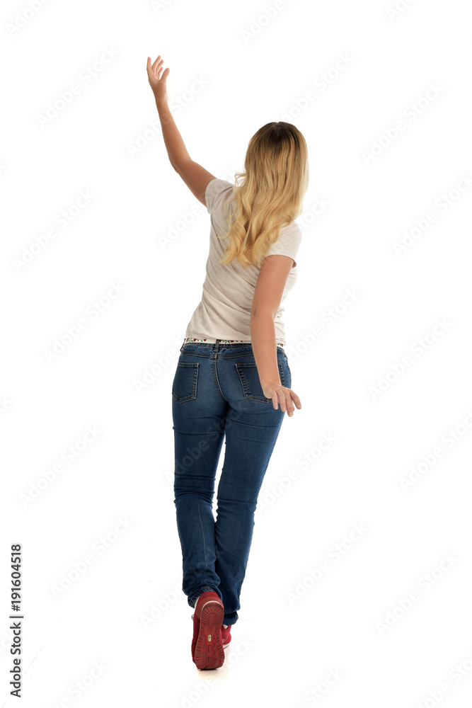 full length portrait of blonde girl wearing simple white shirt and jeans, standing pose, isolated on white studio background. full length portrait of blonde girl wearing simple white shirt and jeans, standing pose, isolated on white studio background.