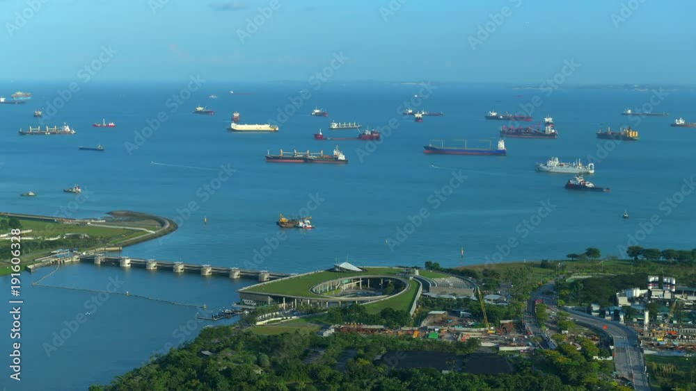 Timelapse 4k Movie Scene of Overlooking view Gardens by the Bay with cargo boats in background. Marina Bay Sands.