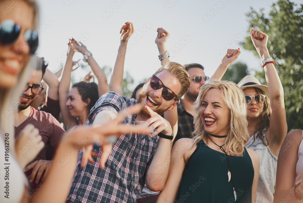 Group of people dancing and having a good time at the outdoor party/music festival Group of people dancing and having a good time at the outdoor party/music festival