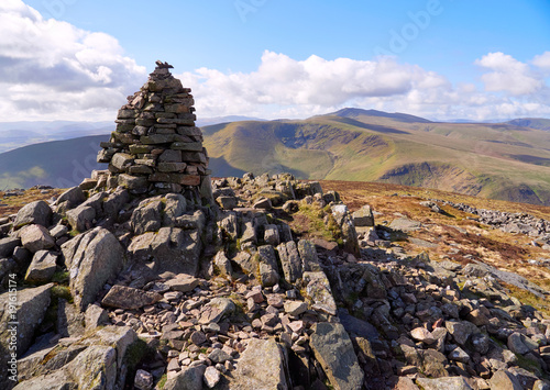 The summit cairn (pile of stones) of Carrock Fell with Bowscale Fell and Blencathra in the distance in the English Lake District, UK. © Duncan Andison