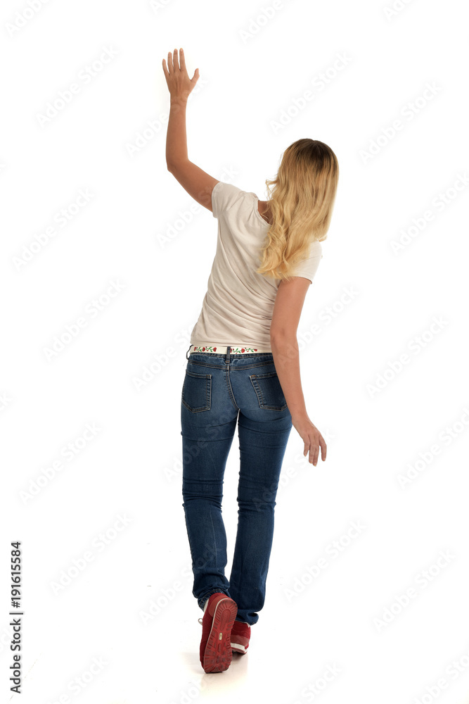 full length portrait of blonde girl wearing simple white shirt and jeans, standing pose, isolated on white studio background. full length portrait of blonde girl wearing simple white shirt and jeans, standing pose, isolated on white studio background.