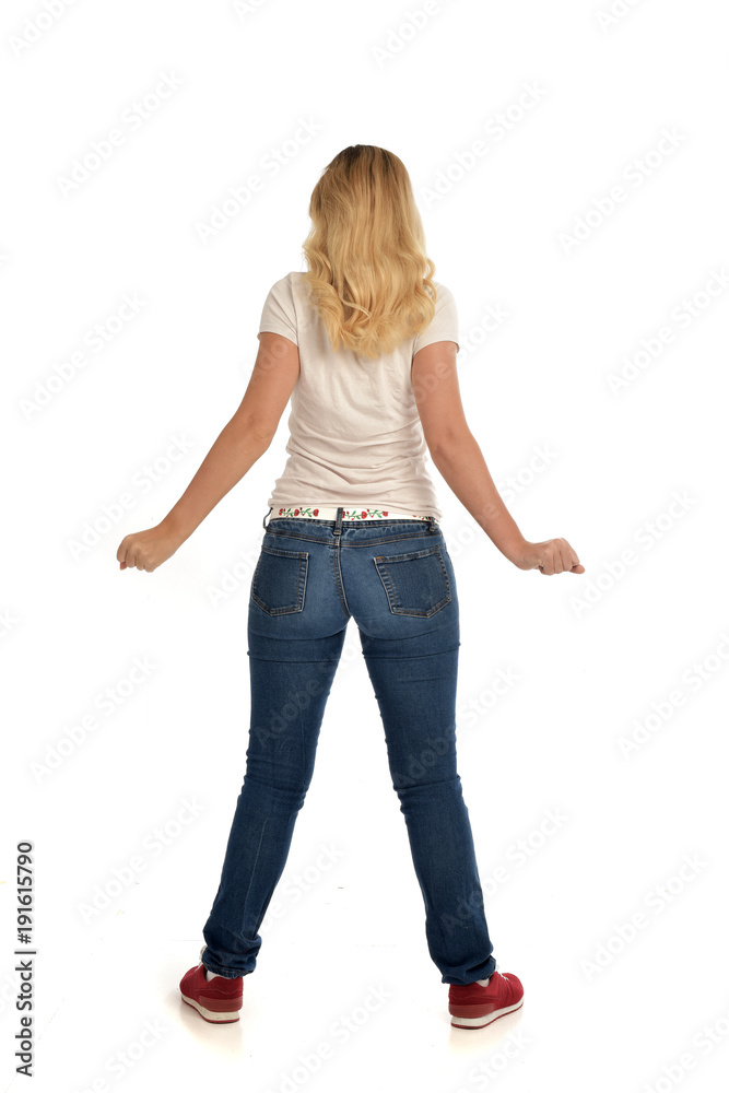 full length portrait of blonde girl wearing simple white shirt and jeans, standing pose, isolated on white studio background. full length portrait of blonde girl wearing simple white shirt and jeans, standing pose, isolated on white studio background.
