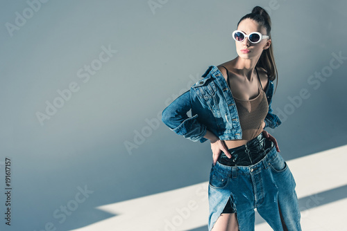fashionable brunette model posing in denim style and sunglasses photo