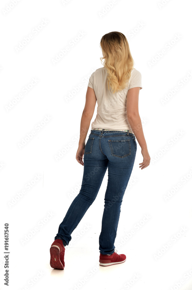 full length portrait of blonde girl wearing simple white shirt and jeans, standing pose, isolated on white studio background. full length portrait of blonde girl wearing simple white shirt and jeans, standing pose, isolated on white studio background.