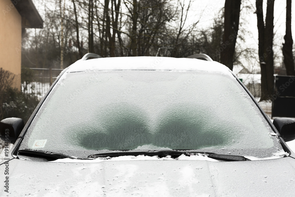 Naklejka premium Defrosting ice from car windshield