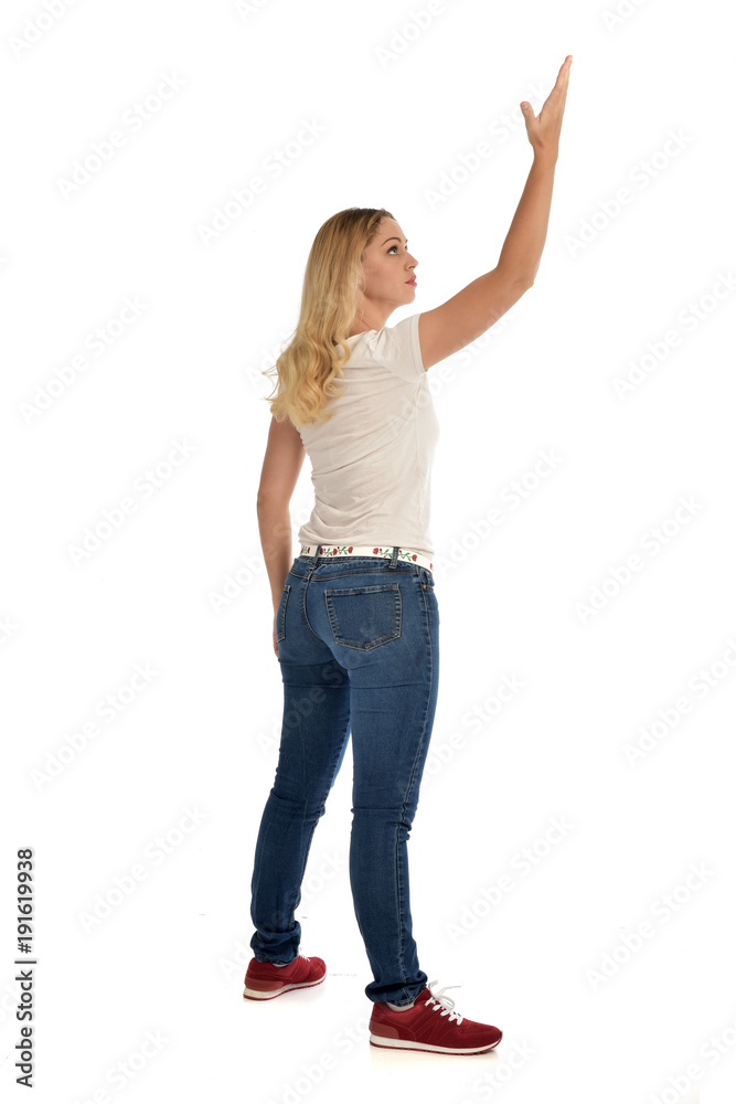 full length portrait of blonde girl wearing simple white shirt and jeans, standing pose, isolated on white studio background. full length portrait of blonde girl wearing simple white shirt and jeans, standing pose, isolated on white studio background.