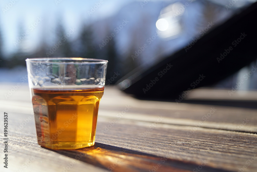Bicchiere di grappa barricata crea una lunga ombra sul tavolo di legno di  una baita in montagna Stock Photo | Adobe Stock
