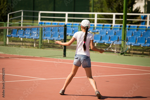 Girl playing with a racket in tennis on the court © schankz