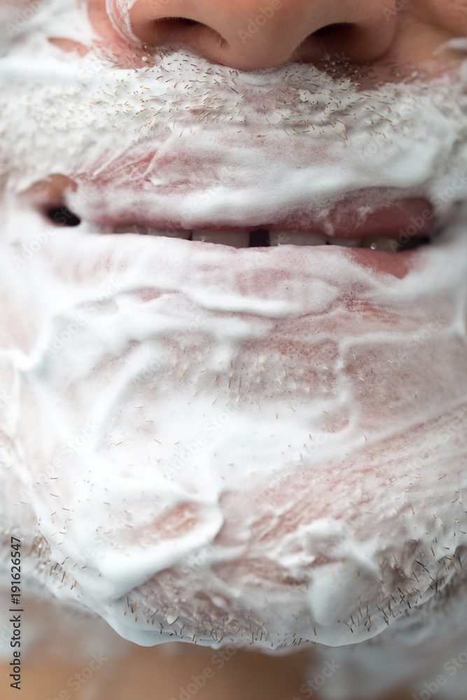 Fototapeta premium A man is applying face shaving foam