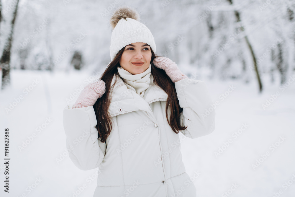 A beautiful and fashoin woman in white warm clothing walking in snowy weather. A beautiful and fashoin woman in white warm clothing walking in snowy weather.