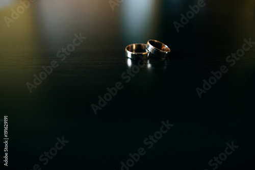 gold wedding rings on a dark wooden background