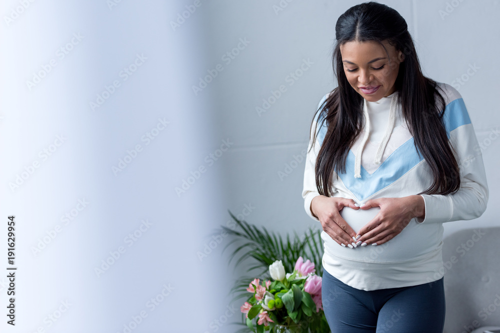 african american pregnant woman making heart symbol with hands on her belly african american pregnant woman making heart symbol with hands on her belly