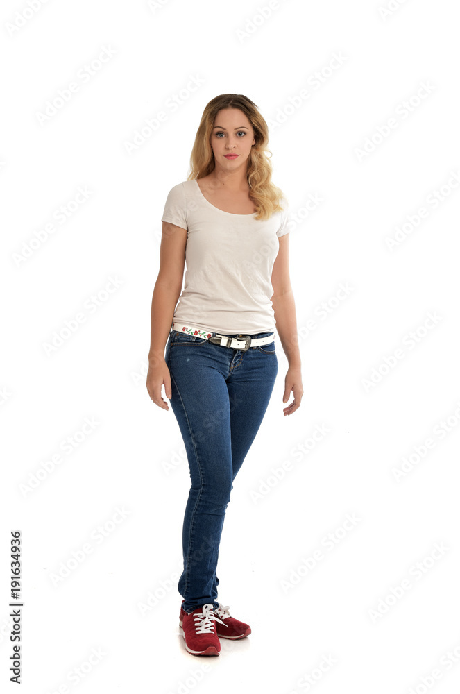 full length portrait of blonde girl wearing white shirt and jeans. standing pose, isolated on white studio background. full length portrait of blonde girl wearing white shirt and jeans. standing pose, isolated on white studio background.