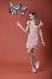 Charming girl holding balloons