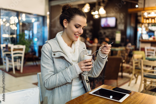 Attractive young woman using tablet in cafe © NDABCREATIVITY