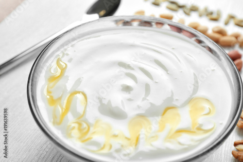 Tasty yogurt with honey in bowl, closeup