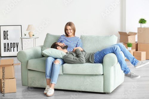 Young couple resting on sofa after moving to new home
