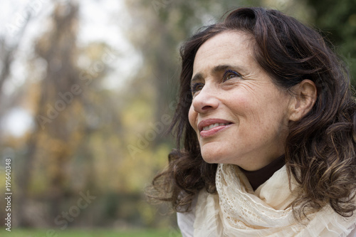 фотографія Portrait of mature woman with a vision look in her eyes at park during fall season