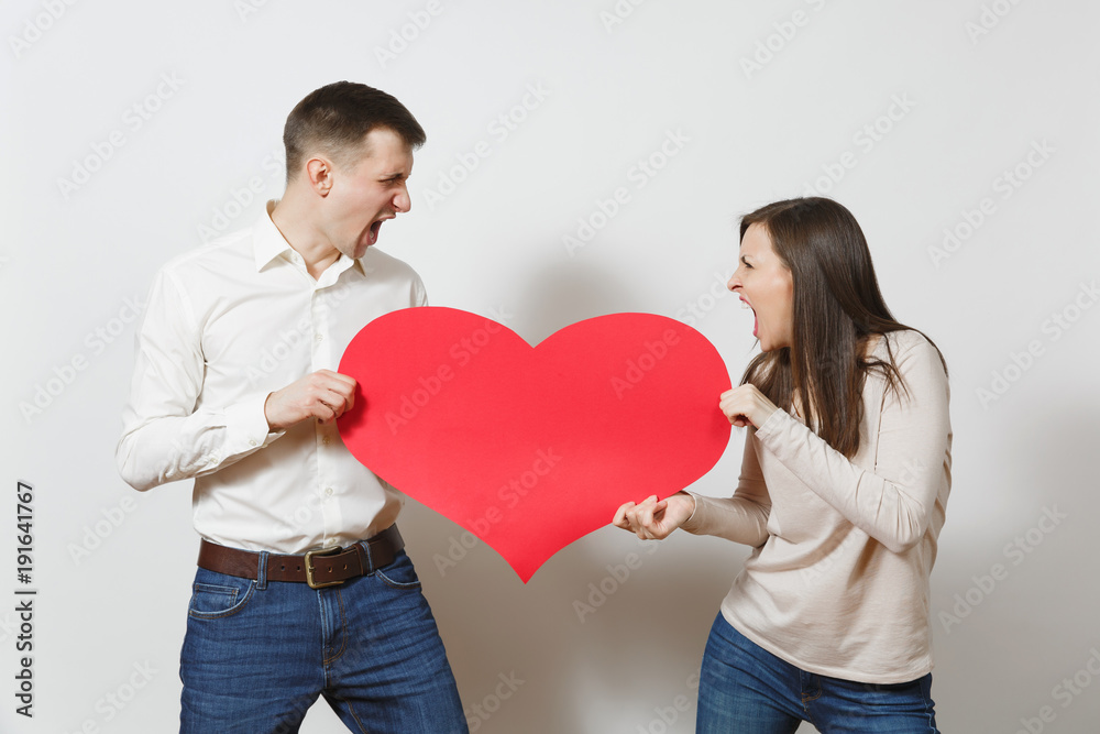 Young couple in love. Man and woman with bir red heart isolated on white background. St. Valentine's Day, International Women's Day, birthday, holiday concept. Quarrel divorce break up of relationship