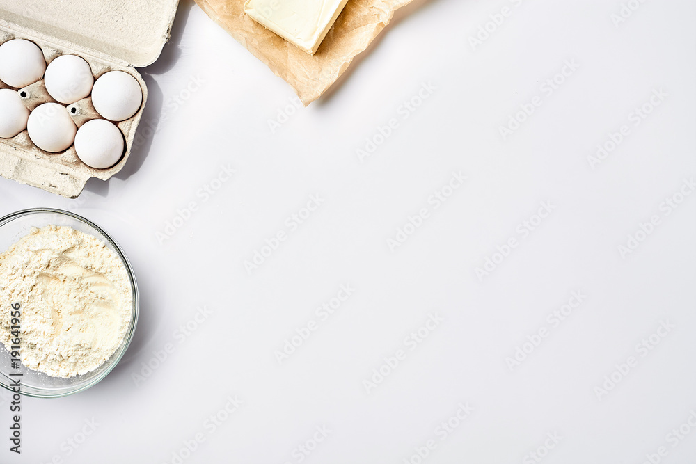 Preparation of the dough. Ingredients for the dough - flour, butter, eggs. On white background. Free space for text . Top view Preparation of the dough. Ingredients for the dough - flour, butter, eggs. On white background. Free space for text . Top view