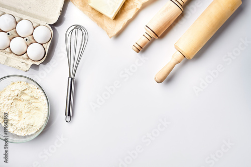 Preparation of the dough. Ingredients for the dough - flour, butter, eggs and various tools. On white background. Free space for text . Top view