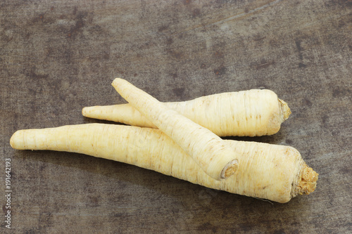 bunch of freshly harvested parsly root on a grungy metal background photo