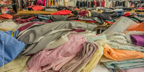 Recycling Verkauf von Secondhand Textilien und Handtaschen auf dem Wühltisch - Recycling Sale of second-hand textiles and handbags on the rummage table
